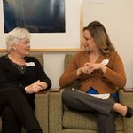 Two ladies sit and converse